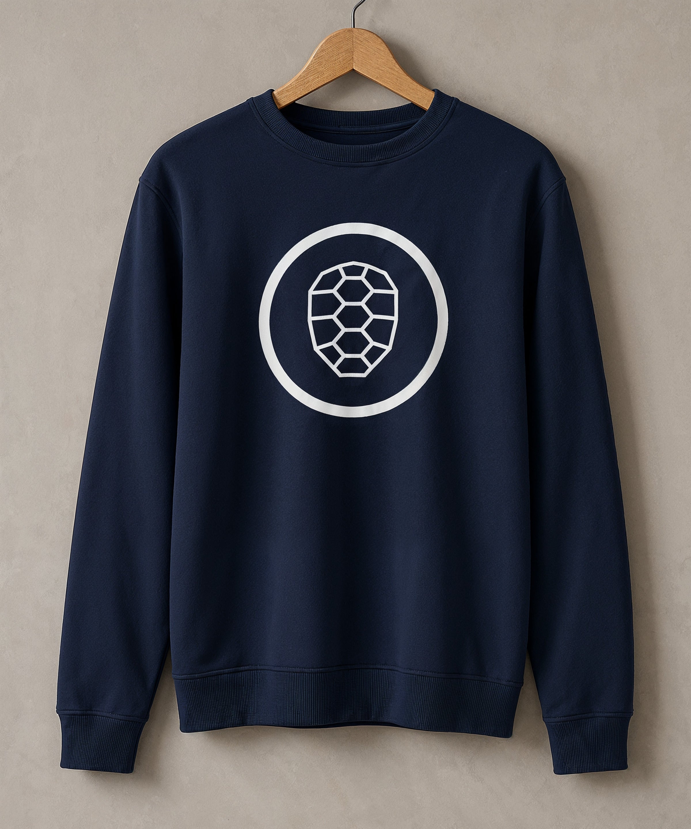 Navy ONETURTLE sweatshirt on a wooden hanger against the studio wall