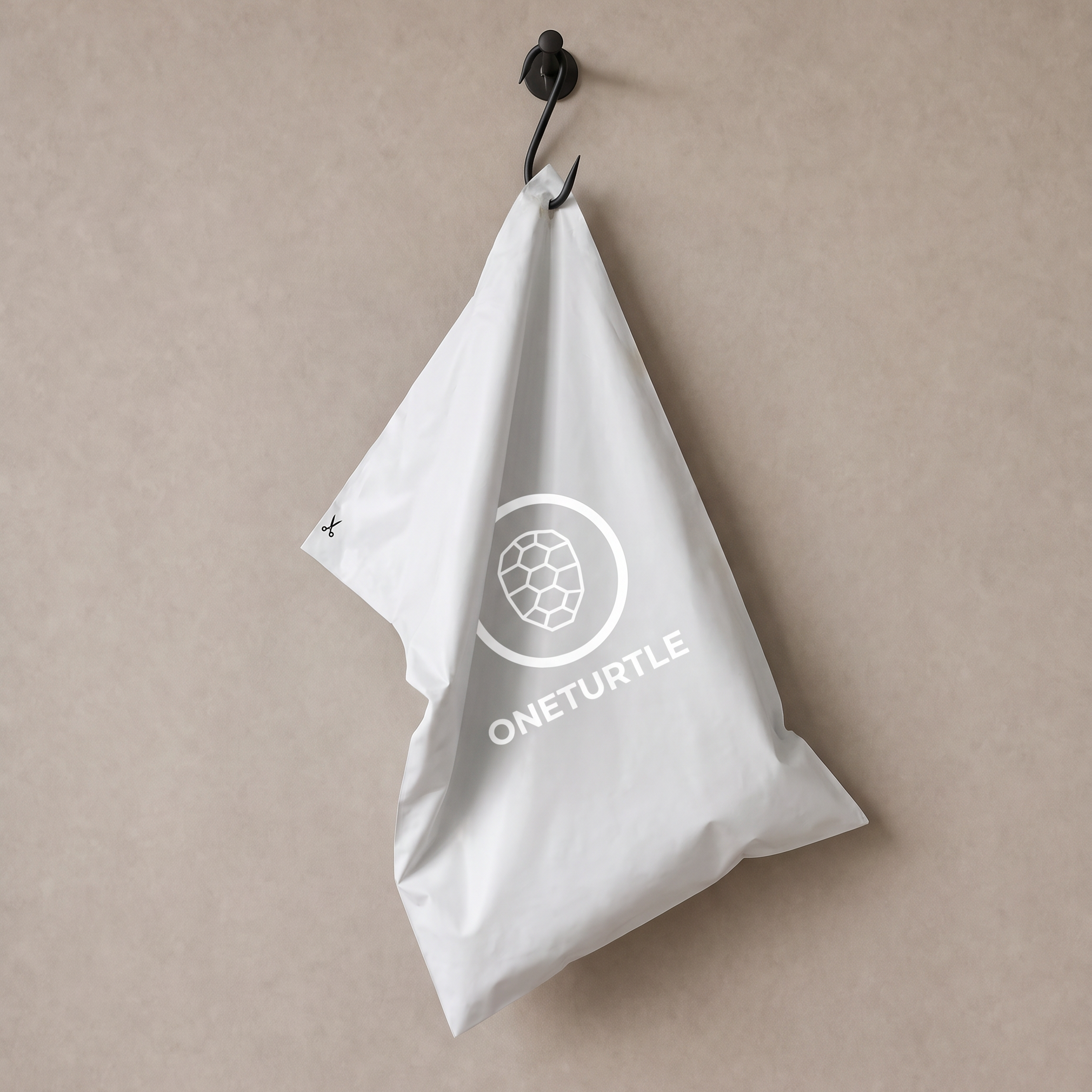 ONETURTLE compostable mailer bag hanging on a metal hook against the studio wall